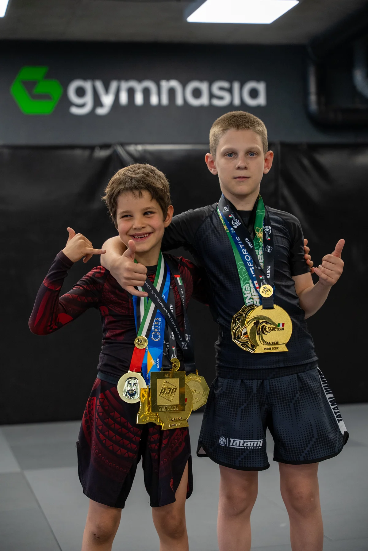 Two young Gymnasia grapplers with IBJJF European Kids, AJP Tour and Grand Slam medals